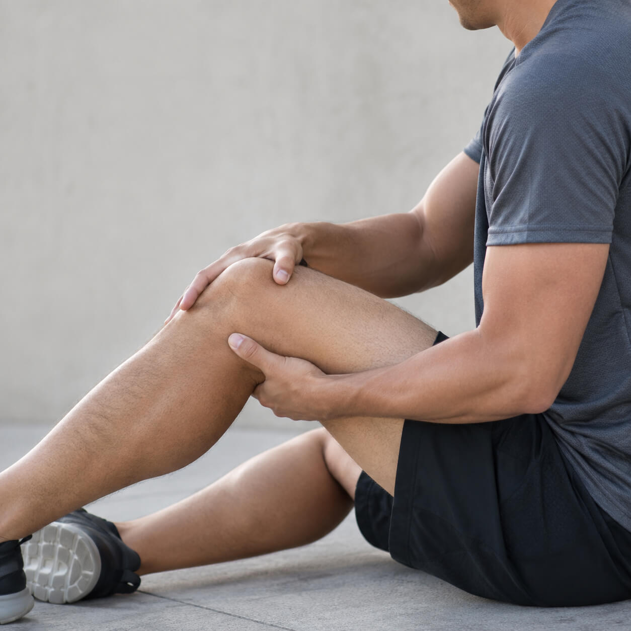 Active adult holding outer knee after a lateral meniscus injury